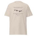 Natural beige T-shirt with black reaching hands and the Be Strong and Courageous Bible verse from Joshua 1:9, front view.