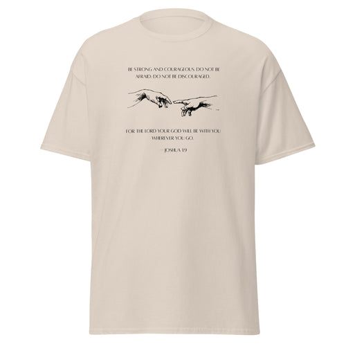 Natural beige T-shirt with black reaching hands and the Be Strong and Courageous Bible verse from Joshua 1:9, front view.