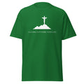 Green T-shirt with a white crucifix on a hill above Anything Is Possible With God lettering, front view.